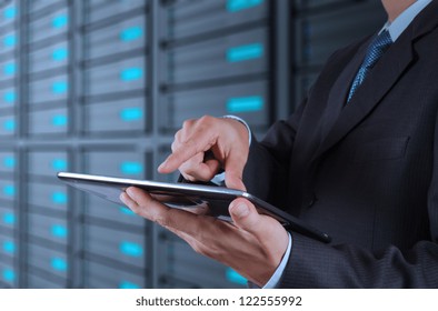 Businessman Hand Using Tablet Computer And Server Room Background