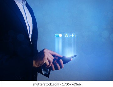 Businessman hand with wifi on smartphone screen.
Wi-Fi wireless concept. Free WiFi network signal technology internet concept.