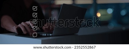 Businessman hand working with laptop computer point to tick correct sign mark in checkbox for quality document control checklist and business approve project.