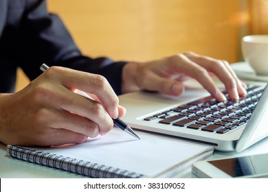 businessman hand working with new modern computer and writing on the notepad strategy diagram as concept morning light
