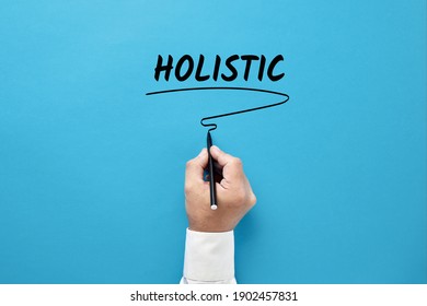 Businessman hand writing the business buzzword holistic on blue background. Holistic approach in business concept. - Powered by Shutterstock