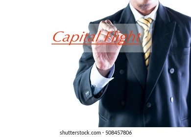 Businessman Hand Writing Capital Flight On Transparent Wipe Board.