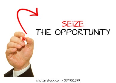 Businessman Hand Writing Seize The Opportunity On A Transparent Wipe Board