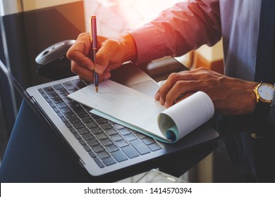 Businessman Hand Writing And Signing White Empty Bank Checkbook With Modern Computer Notebook And Wireless Mouse On The Desk At Office. Payment By Check, Paycheck, Payroll, Cheque Sign Conceptual.