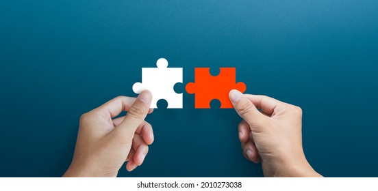 Businessman hands connecting puzzle pieces representing the merging of two companies or joint venture, partnership, Mergers and acquisition concept - Shutterstock ID 2010273038