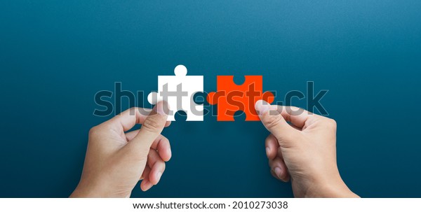 Businessman hands connecting puzzle pieces\
representing the merging of two companies or joint venture,\
partnership, Mergers and acquisition\
concept