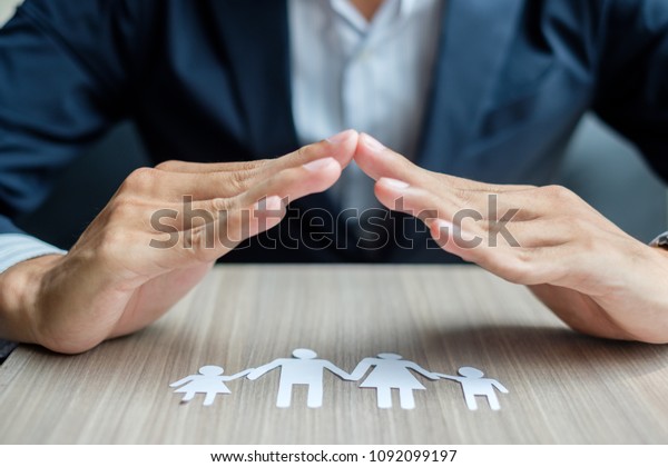 Businessman hands cover Family paper. Healthcare
and Insurance
concept