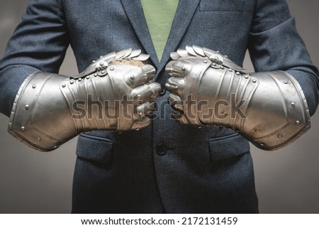 Businessman hands in the plate armor mittens close up. Help of a lawyer. Business protection concept.