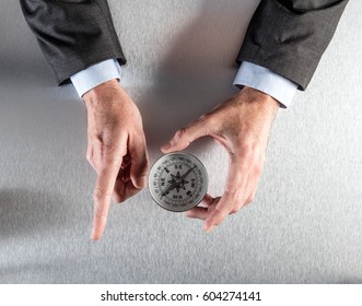 Businessman Hands Showing A Career Or Corporate Direction, Management Strategy Or The Way Forward With A Compass In His Workplace, Flat Lay View