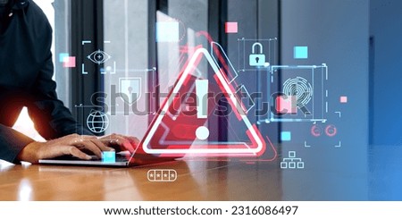 Businessman hands typing on laptop with triangular malware caution warning sign. Virus scam phishing cyber crime concept. Password hacking