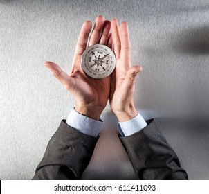 businessman hands using a compass for exploration symbol, searching for the company direction, perspective, vision, management or idea forward, above view
