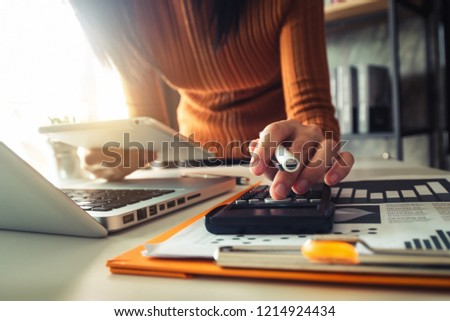Businessman hands working with finances about cost and calculator and laptop with tablet, smartphone at office in morning light
