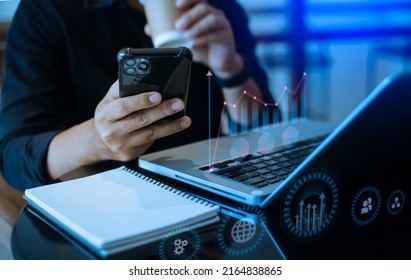 Businessman Hands Working On Smartphone And Laptop Computer With Digital Finance Marketing Chart And Future Technology Innovation And Digital Transformation Concept.