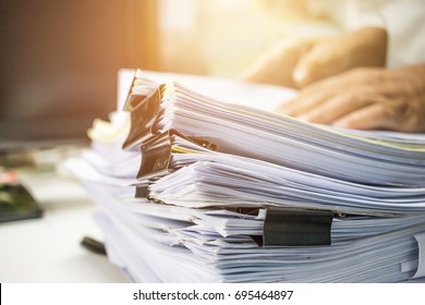Businessman hands working in Stacks of paper files for searching information on work desk office, business report papers,piles of unfinished documents achieves with clips indoor,Business concept - Shutterstock ID 695464897