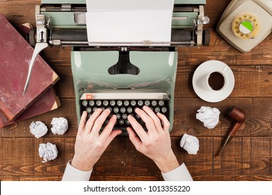 hombre de negocios escribe con la mano sobre una vieja máquina de escribir