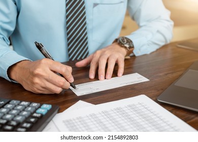 Businessman hands writing and signing check. business, finances and money concept.
