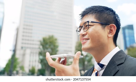 A businessman hands-free calling on a smartphone. - Powered by Shutterstock