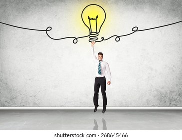 Businessman hanging on an idea bulb - Shutterstock ID 268645466