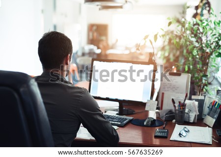 Businessman hard at work on a computer in an office