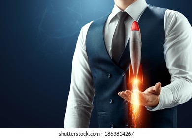 The businessman has a rocket taking off in his palm. The concept of a startup, profit increase, scaling. Mixed environment