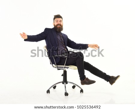 Businessman having fun. Cheerful businessman sitting on the office chair with his arms raised while isolated on white