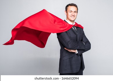 A businessman in a hero red cape and a mask in front view looking in the distance over his shoulder on white background. Business and success. Planning and analyzing. Past mistakes.