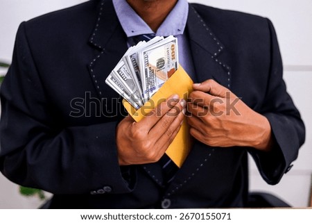 Businessman Hides Stack of US Dollars in Yellow Envelope Under Suit Jacket
