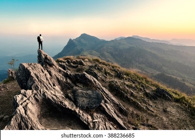 бизнесмен поход на вершину горы скалы на закате, успех, победитель, концепция лидера