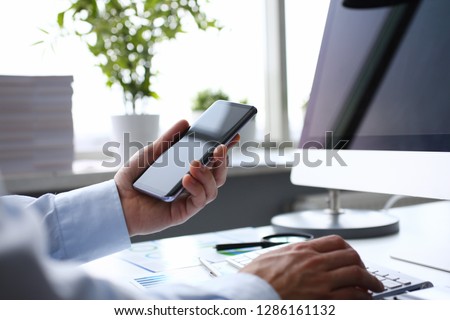Businessman hipster holds telephone background of computer keyboard in office clodeup. Make transaction money mobile wallet cryptocurrency payment for goods services remote access management concept