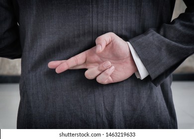 Businessman With His Fingers Crossed Behind His Back.Dishonest Relationship And Betrayal Concept