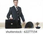 Businessman in his office with briefcase