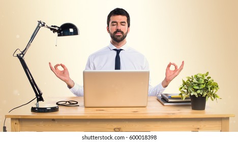 Businessman In His Office In Zen Position On Ocher Background