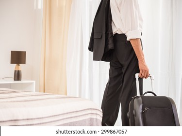 Businessman with his suitcase at the hotel room. Back view. Close-up. - Powered by Shutterstock