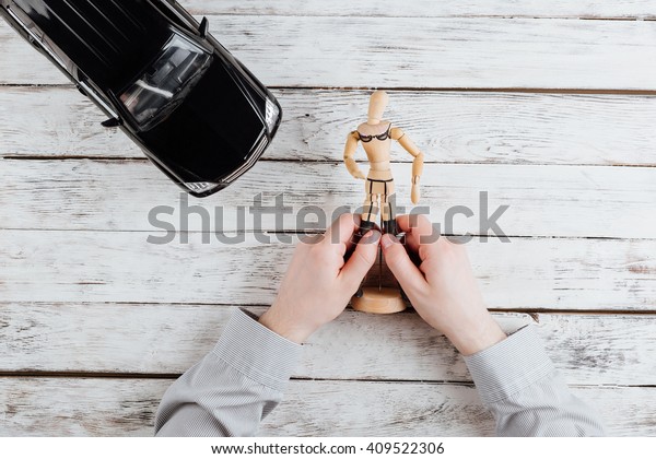 businessman hold\
drawing model human female manikin, wooden office table. the work\
place on background. business and technology concept. desktop top\
view, , dreams of a car or\
woman