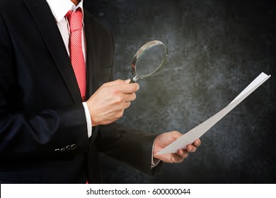 Businessman Hold Magnifying Glass And Investigate Documents