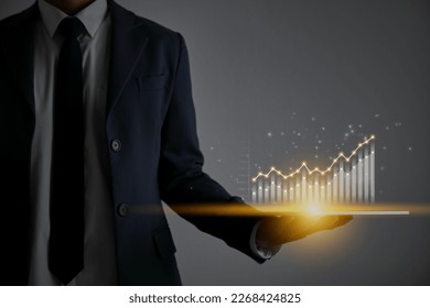 Businessman Hold Tablet Left Hand and Stock Market Graph,Bar Chart, and Line Graph Trend. Business Growth,Financial, Economic and Technology Concept