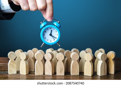 A businessman is holding an alarm clock over a crowd of people. Time management. Hourly wages, strict work limits and time allotted for rest. Urgently, speeding up, deadline. Test, trial period