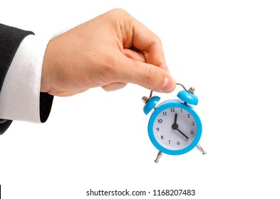A businessman is holding an alarm clock. Watch in hand. The concept of hourly pay, time. Late for work. Full or incomplete rate. Overtime at work. Pension and savings contributions. - Shutterstock ID 1168207483