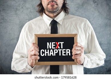 Businessman Holding Blackboard With NEXT CHAPTER Title. Advance In Business.