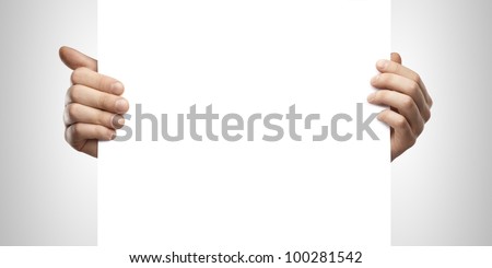 Businessman holding a blank white board. Male hands holding a blank white panel. On a gray background