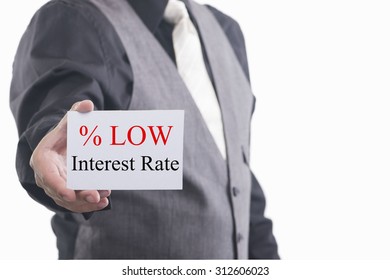 A Businessman Holding A Business Card With The Words, Low Interest Rates, Written On It.