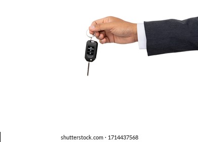 A businessman holding a car key on isolated background and clipping path - Shutterstock ID 1714437568