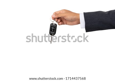 A businessman holding a car key on isolated background and clipping path
