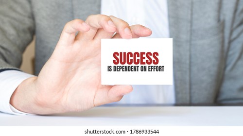 Businessman Holding A Card With Text Success Is Dependent On Effort