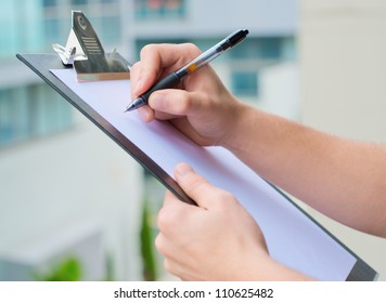 Businessman Holding A Clipboard And Writing, Out Door