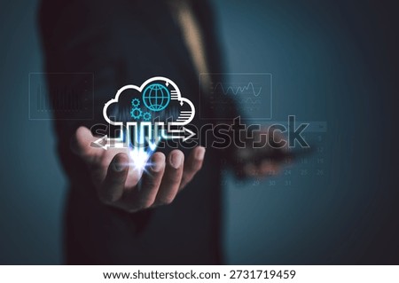 Businessman holding a cloud computing interface with data flow, analytics charts, and digital network elements, representing modern cloud technology, data management, and scalable business infrastructure.