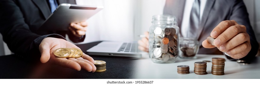 businessman holding coins putting in glass and using calculator. concept saving money and finance accounting. - Shutterstock ID 1955286637