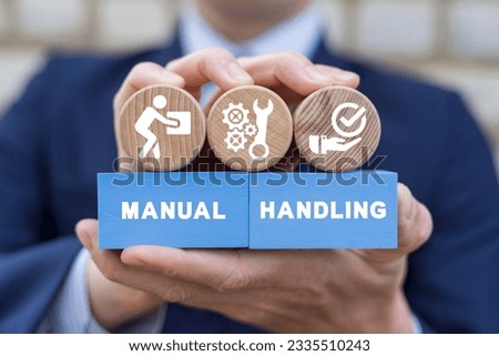 Businessman holding colorful blocks with icons and inscription: MANUAL HANDLING. Concept of manual handling. Right and Wrong Manual Handling and Lifting of Heavy Goods.
