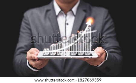 Businessman holding computer tablet with virtual bar graph and increase arrow, Stock investment and dividends yield from business profit growth concept.