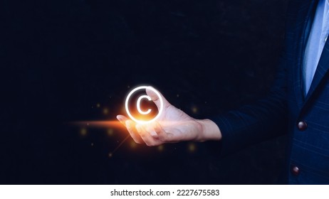 Businessman holding Copyright icon, patents and intellectual property protection law and rights. with symbol of the copyright.copyright symbol from the author. - Shutterstock ID 2227675583